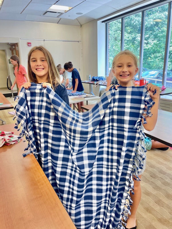 Blanket makers displaying their handcrafted donations