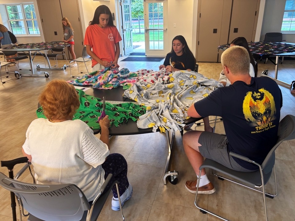 Volunteers tying fleece blanket edges together