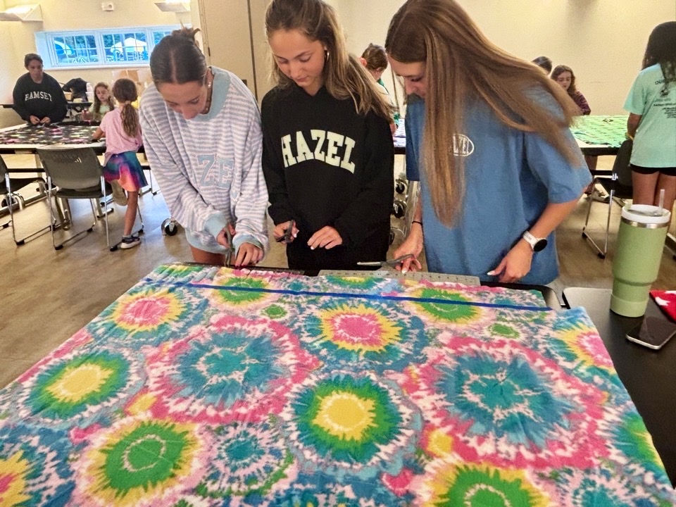 Volunteers preparing a fleece blanket for tying