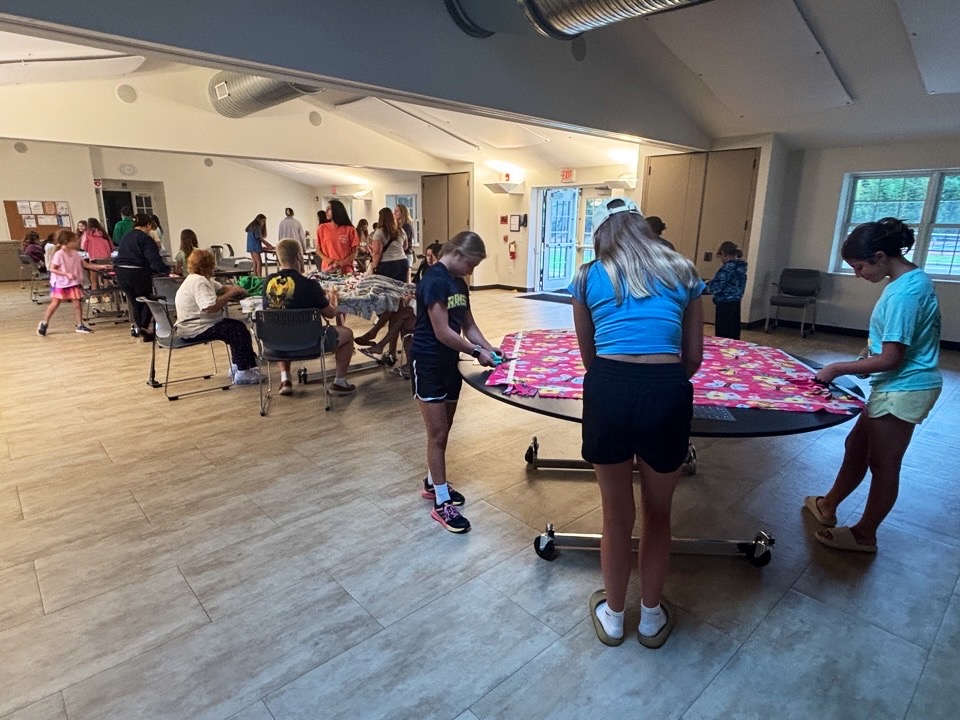 A group making no-sew fleece tie blankets
