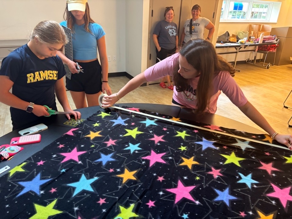 Volunteers measuring fleece strips for a no-sew blanket