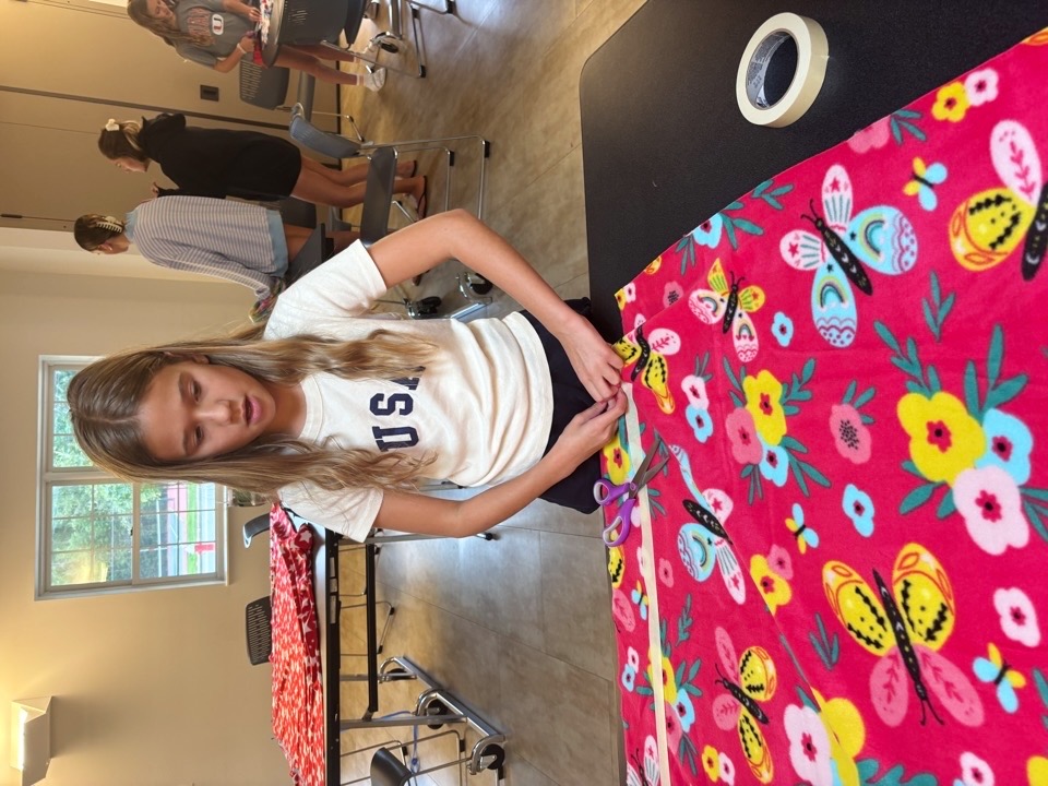 Volunteers working around a fleece tie blanket table