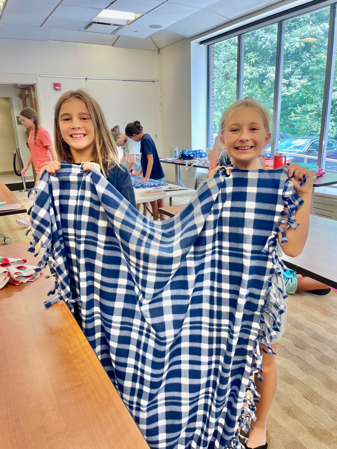 Blanket makers displaying their handcrafted donations