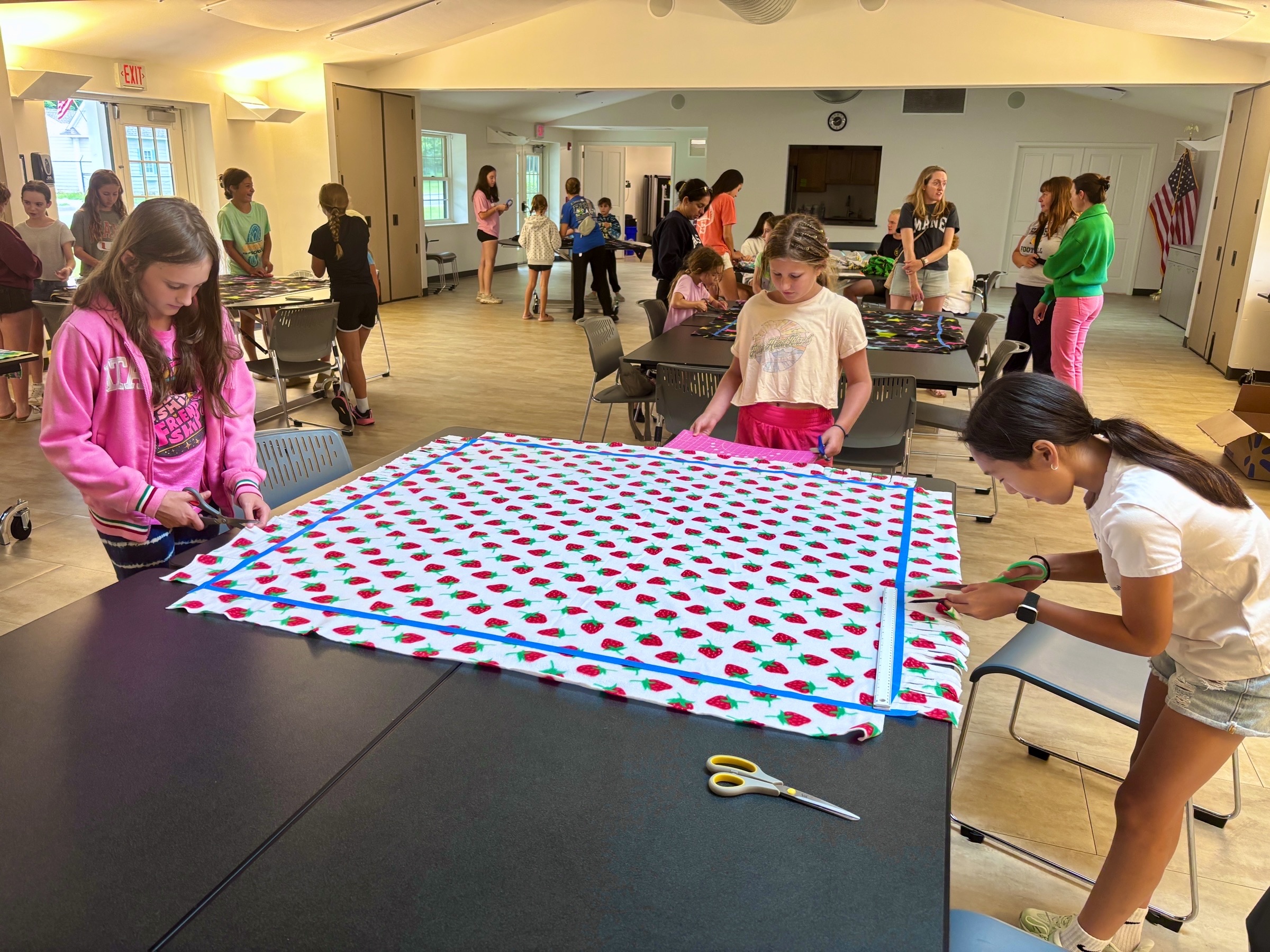 Volunteers making a no-sew fleece tie blanket at the August 30 community event