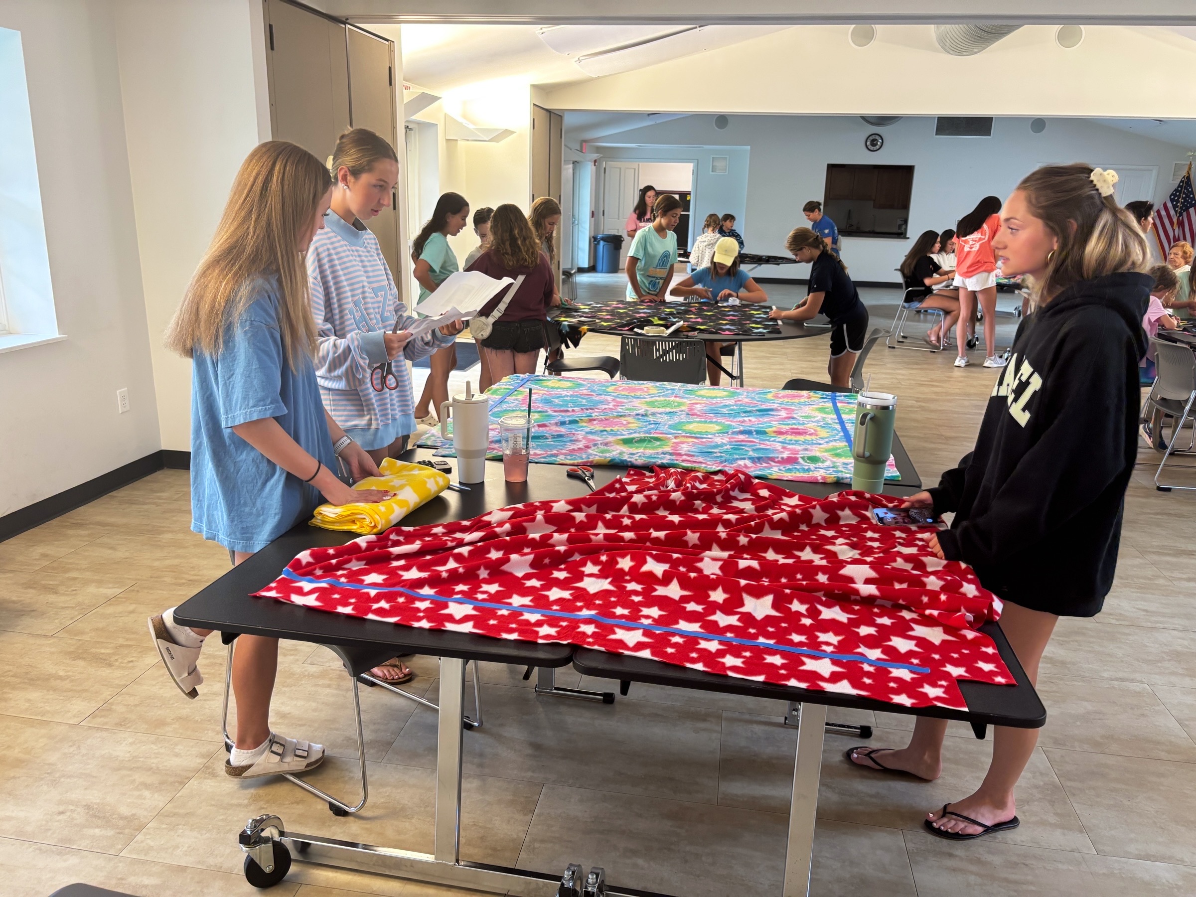 Community members working together on a fleece tie blanket