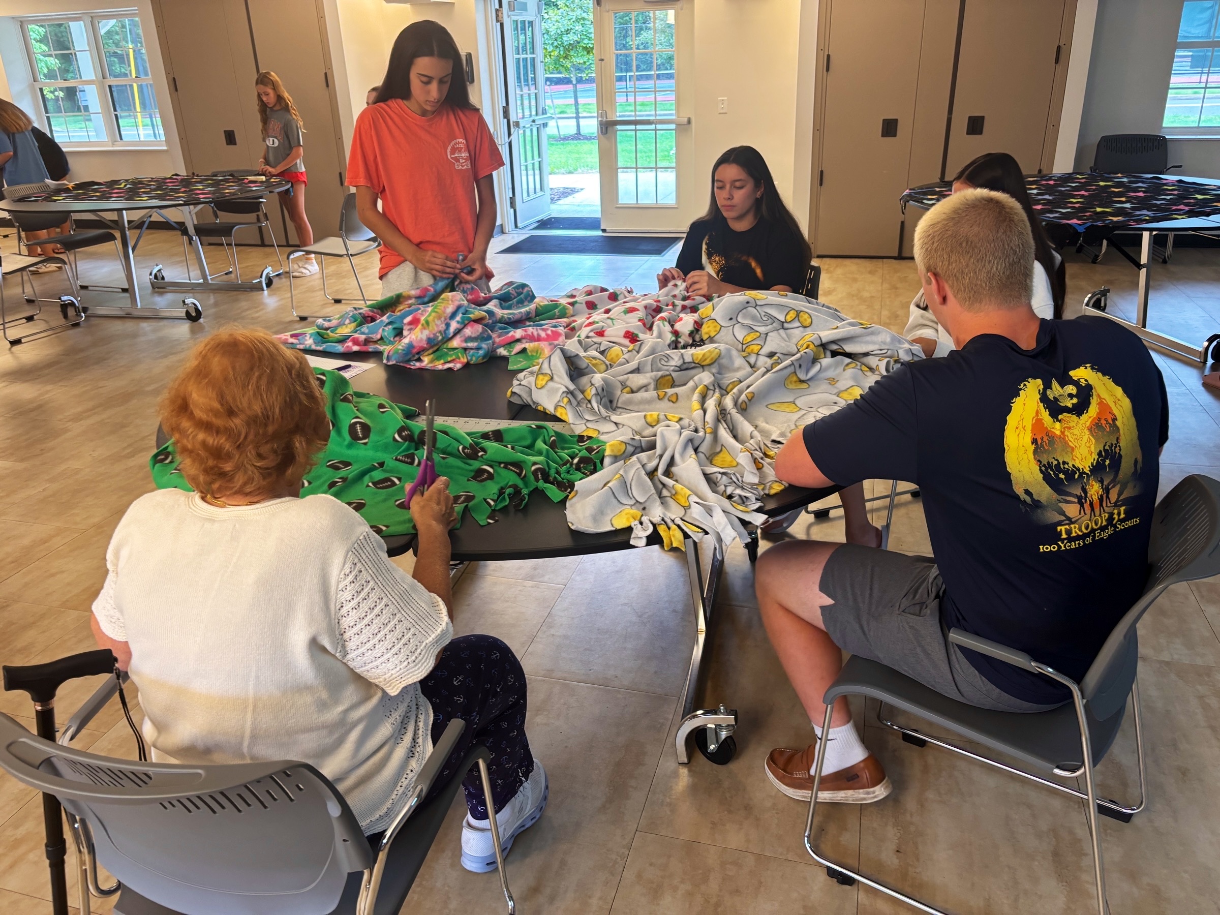 Volunteers tying fleece blanket edges together