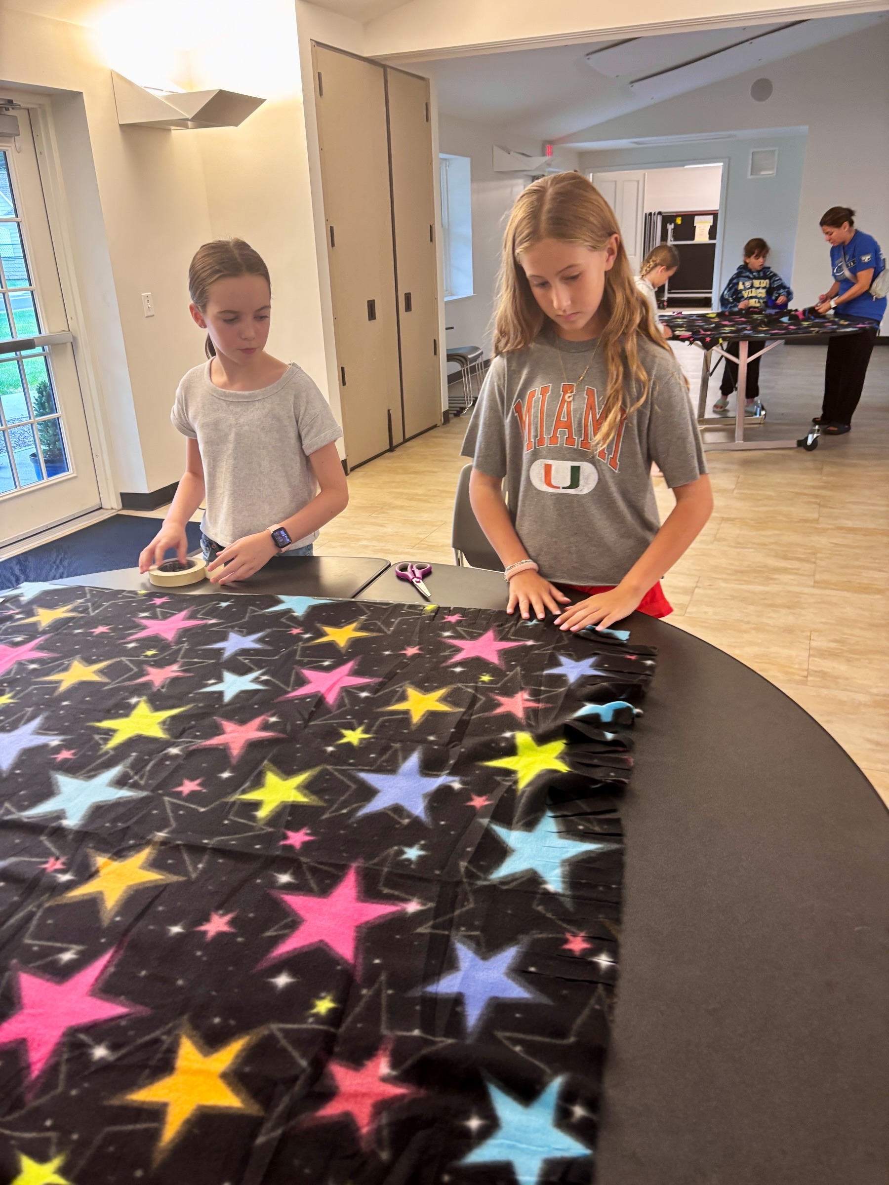 Volunteers preparing fleece material for blanket making