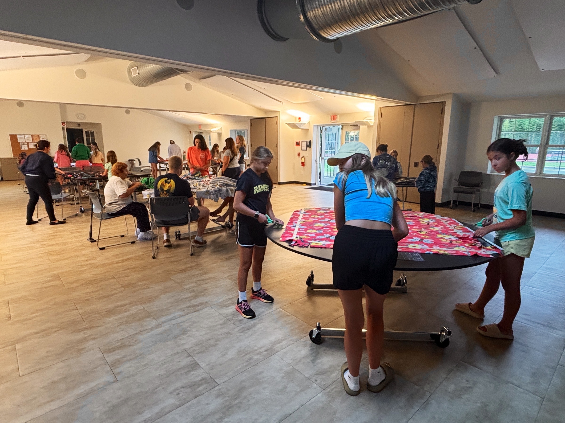 Community members gathered at blanket-making tables