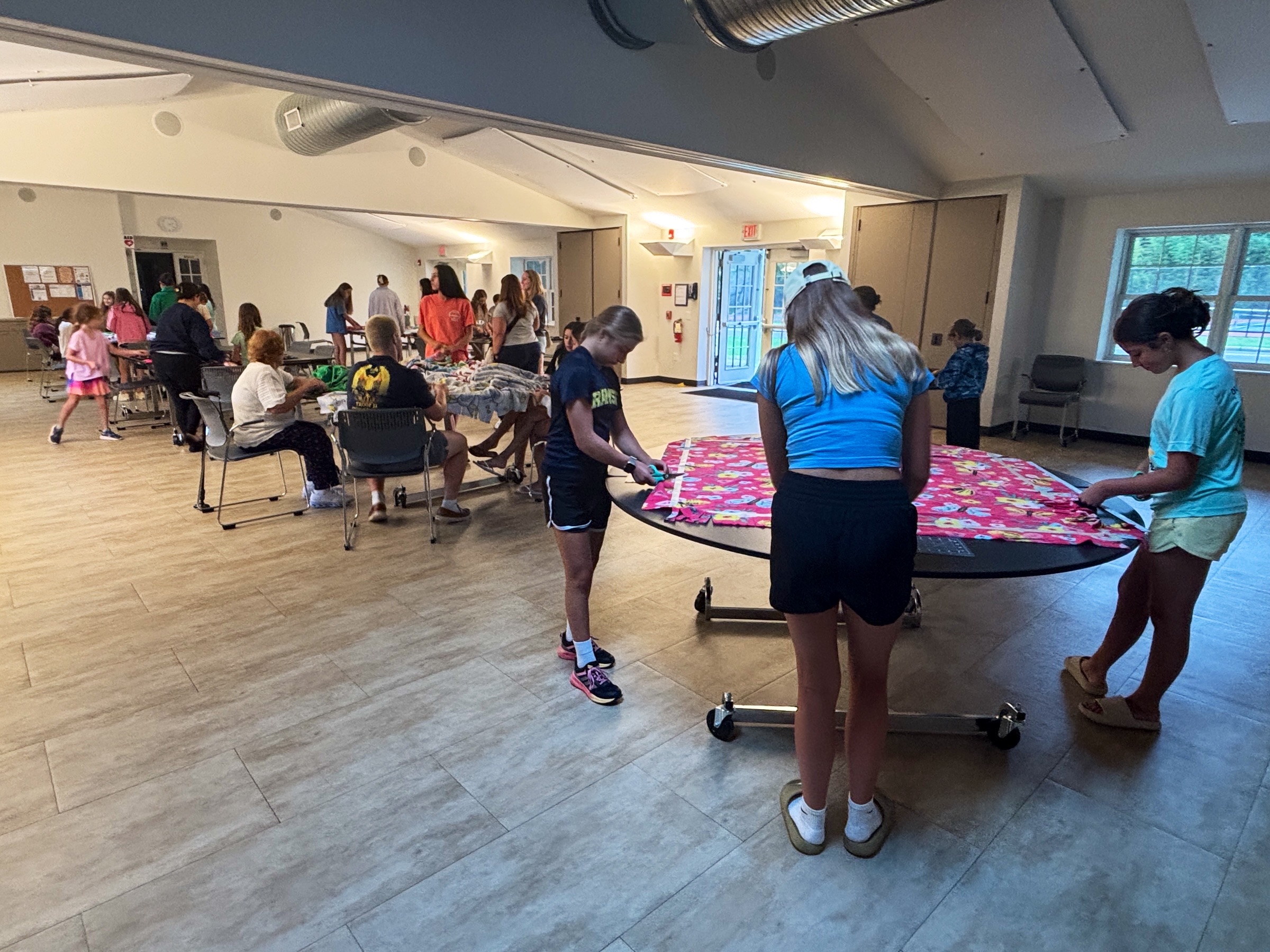 A group making no-sew fleece tie blankets